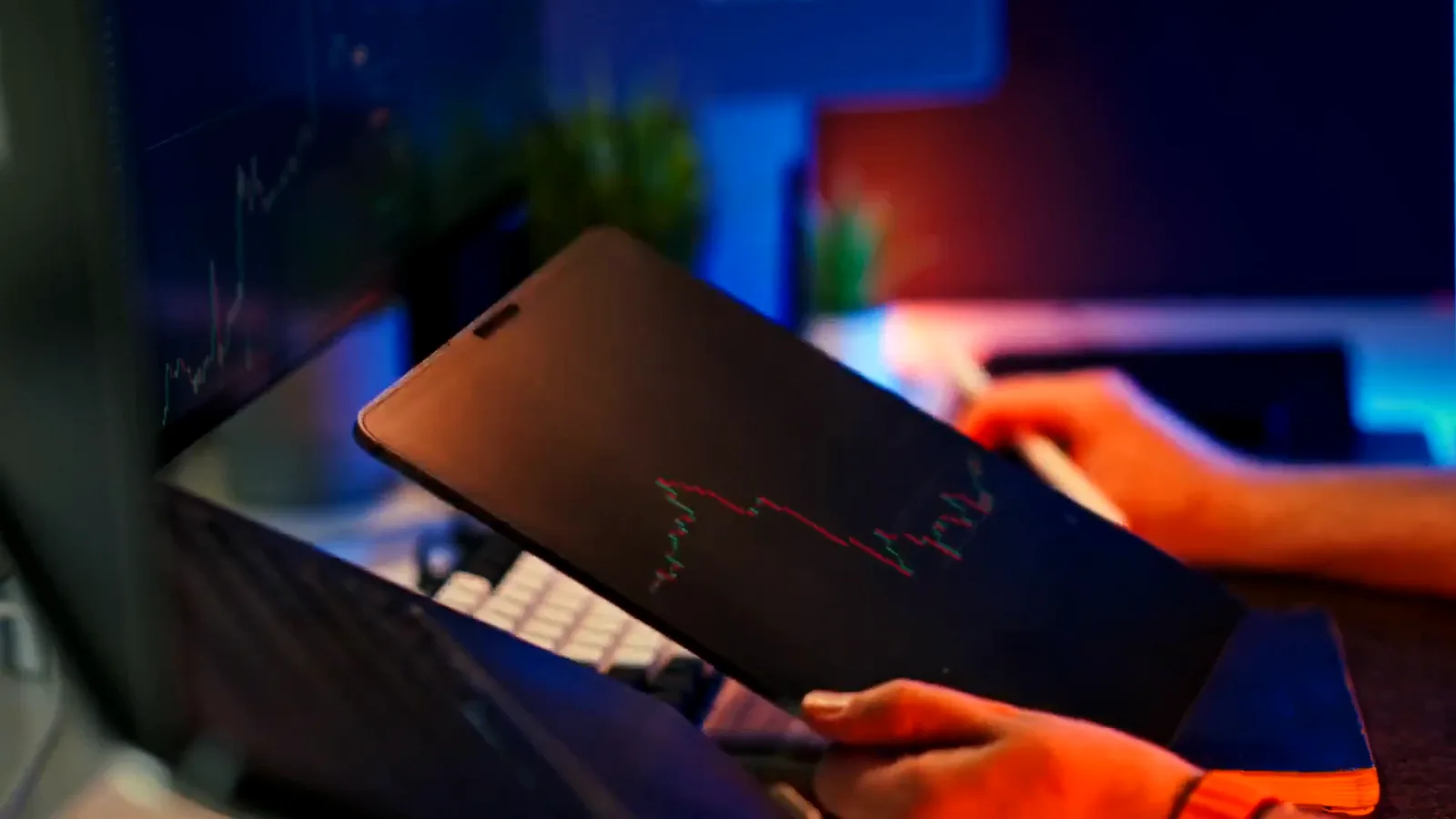 Hands holding a smartphone with a falling red chart reflected on its screen while checking an exchange during a market crash Hands holding a smartphone with a falling red chart reflected on its screen while checking an exchange during a market crash
