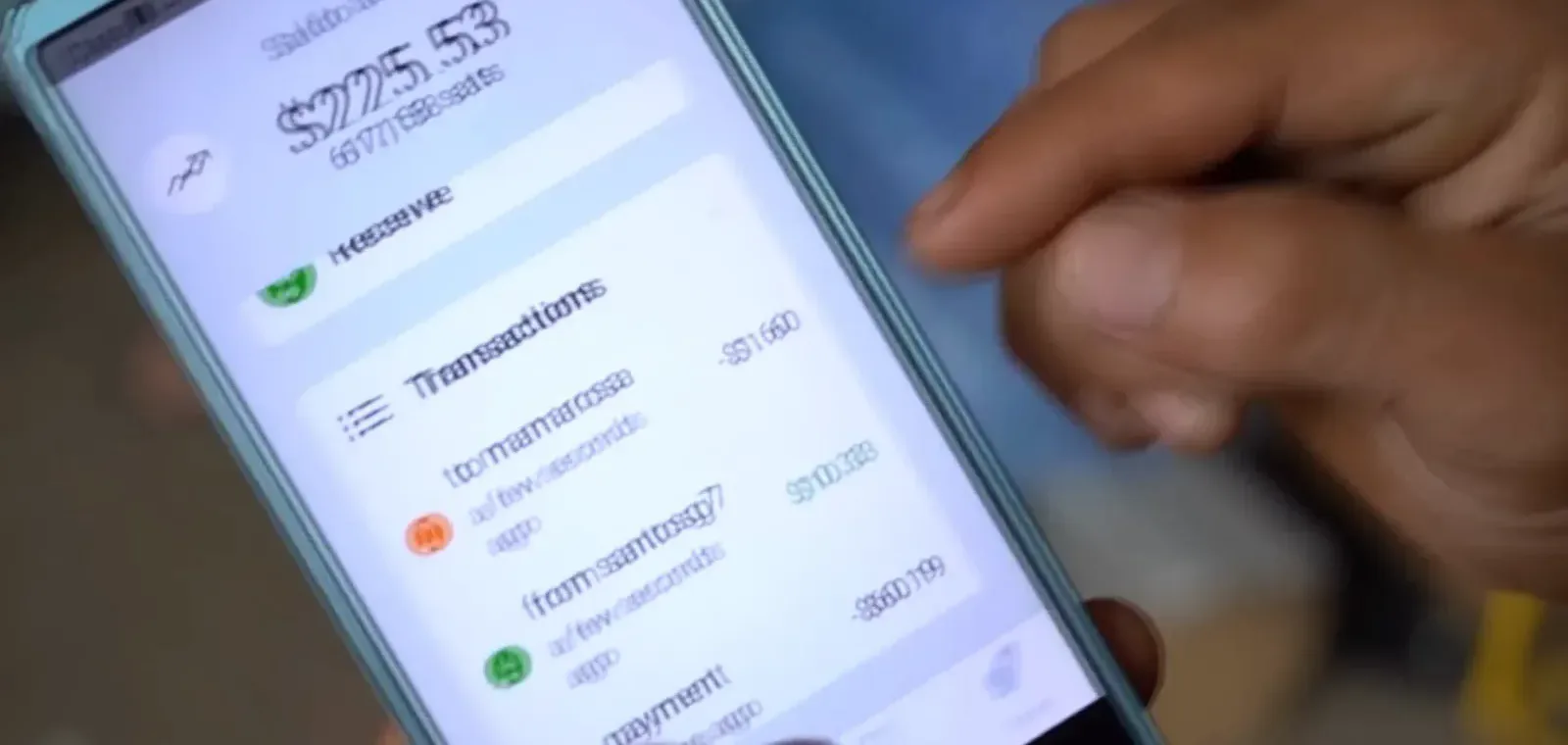 Hand holding a phone showing a 275 dollar Chivo wallet balance with its transaction list, the balance most Salvadorans spent down and abandoned Hand holding a phone showing a 275 dollar Chivo wallet balance with its transaction list, the balance most Salvadorans spent down and abandoned