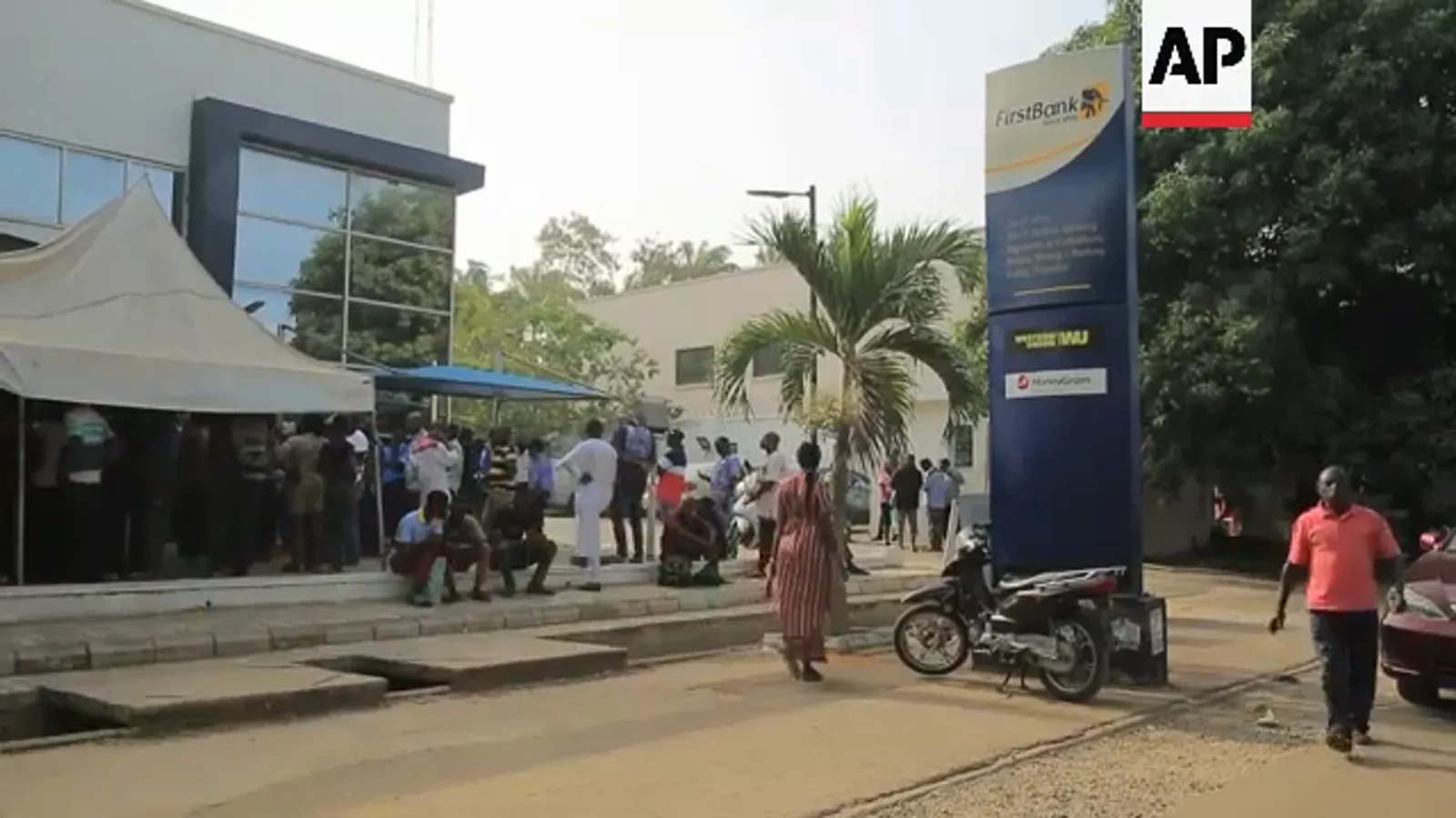 Crowd of customers waiting under tents and canopies outside a Nigerian bank during the 2023 cash crisis