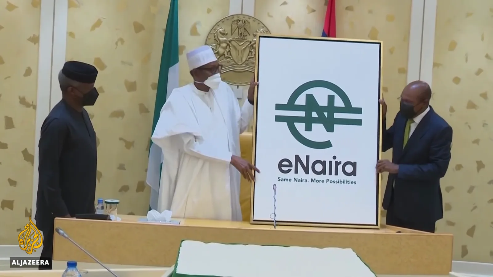 President Buhari flanked by officials pulling the cover off the eNaira logo board at the October 2021 launch ceremony broadcast by Al Jazeera