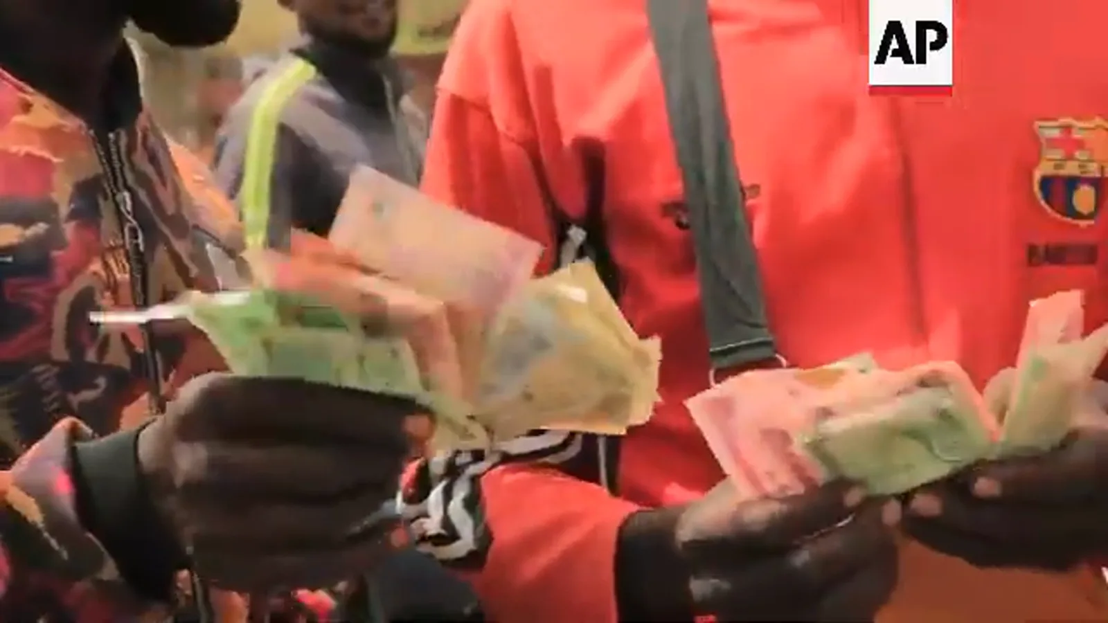 Hands fanning out the last few naira notes a street trader holds during Nigeria's 2023 banknote shortage