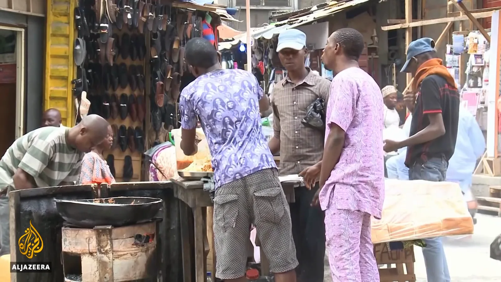 Street vendors selling under umbrellas beside a pedestrian bridge in Lagos, Nigeria's informal cash economy at work